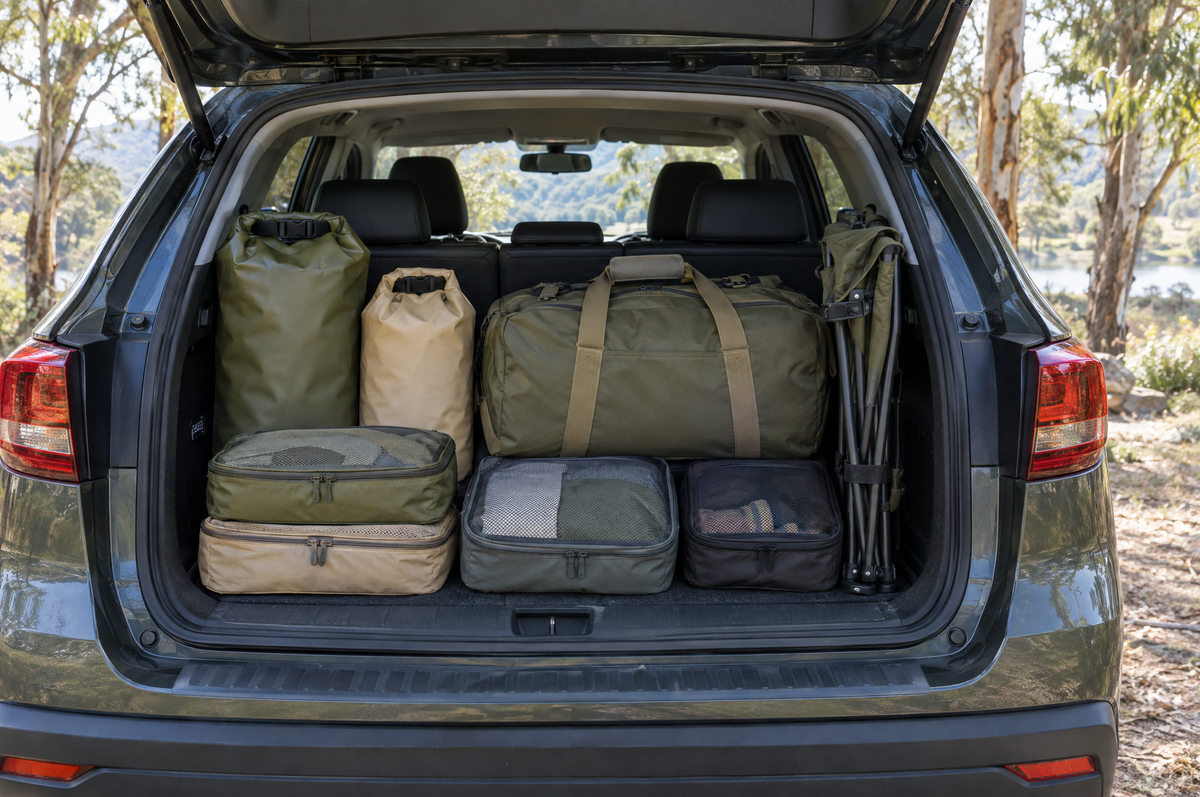 Neatly packed car boot with duffel bag, dry bags and packing cubes