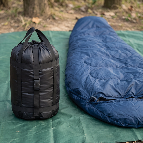 Compressed sack next to a sleeping bag